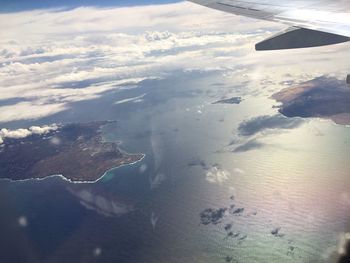 Aerial view of sea and airplane wing