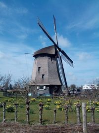 Traditional windmill on land against sky