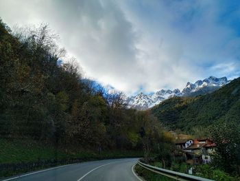 Road amidst trees against sky