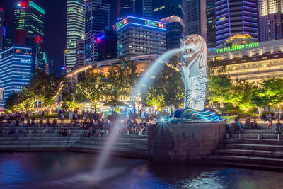 Crowd at illuminated city buildings at night