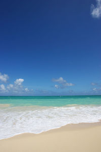 Scenic view of beach against blue sky