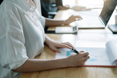 Midsection of woman working at table