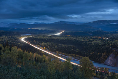 Long exposure of vehicles on road against sky at night