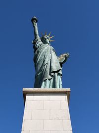 Low angle view of statue against blue sky