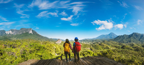 Rear view of woman walking on mountain against sky