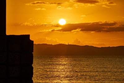 Scenic view of silhouette mountains against orange sky