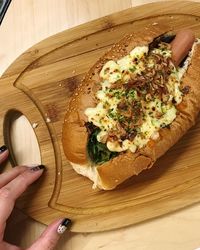 Close-up of hand holding food on cutting board