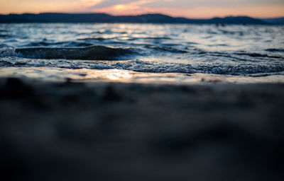 Surface level of sea against sky during sunset