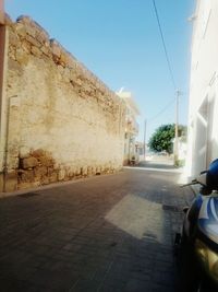 View of empty road against clear blue sky