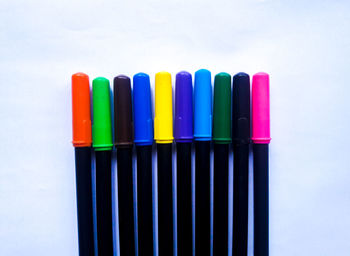 Close-up of colored pencils over white background