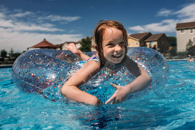 Center shot of young girl floating in neighborhood pool