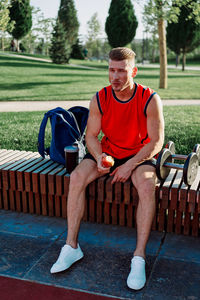 Side view of man sitting on bench
