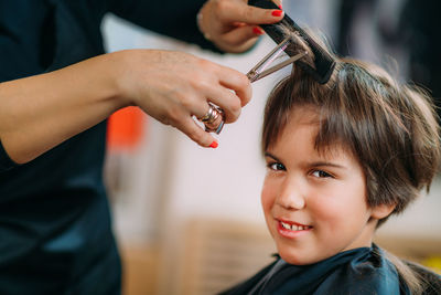 Boy having his hair cut in hairdresser's salon