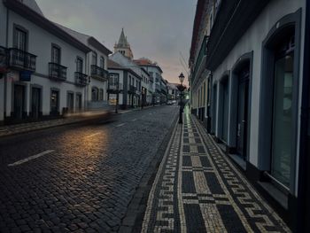 Road amidst buildings at night