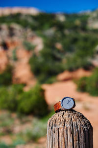 Watch with leather strap on post in the outdoors.