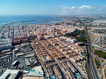 High angle view of city by sea against sky