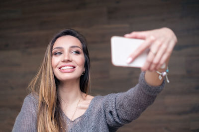 Portrait of smiling young woman using mobile phone