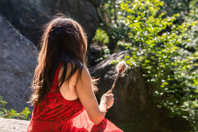 Rear view of woman with red leaves