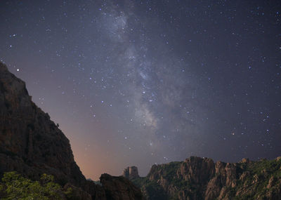 Low angle view of mountains against star field