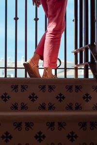 Low section of woman walking on steps against sky