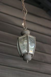 Low angle view of lamp hanging against wall