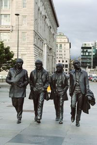 Full length of people walking in city against sky