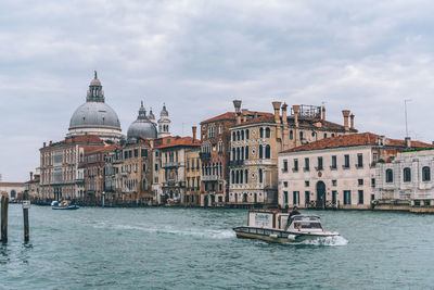 View of boats in water against cloudy sky