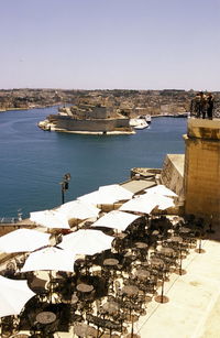 Empty chairs and tables against the river