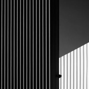 Metal fence with shadow on white wall background