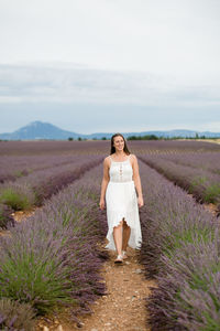 Full length of woman standing on field against sky