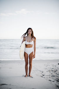 Portrait of young woman standing on beach