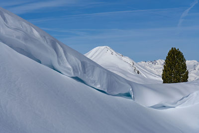 Scenic view of snow covered mountains against sky