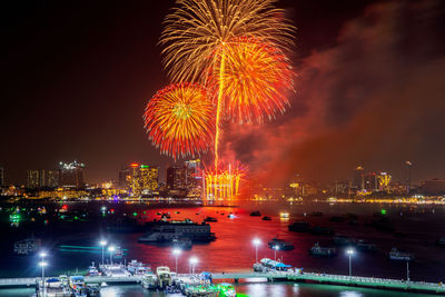 Firework display over illuminated buildings in city at night