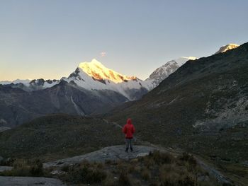 Rear view of man standing on mountain during winter