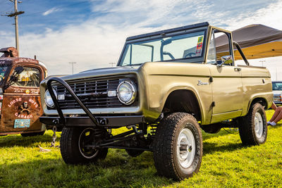 Vintage car on field against sky