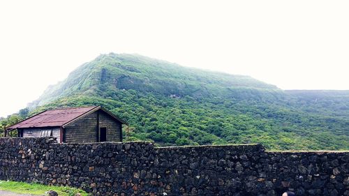 House on mountain against clear sky