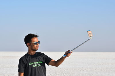 Man standing on beach against clear sky