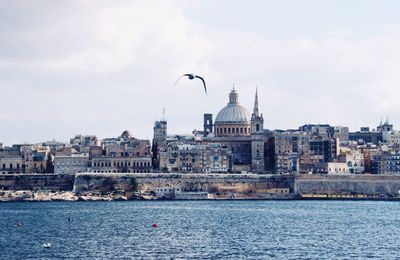 Buildings in city against cloudy sky