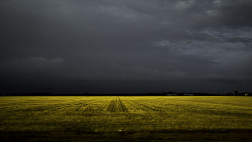 Scenic view of field against cloudy sky