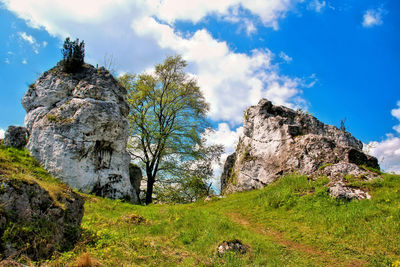 Low angle view of rock formation against cloudy sky