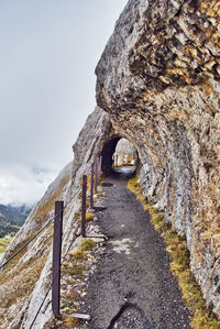 Old stone wall by mountain against sky