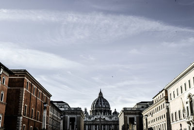 Buildings in city against cloudy sky