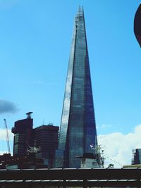 Low angle view of skyscrapers against blue sky