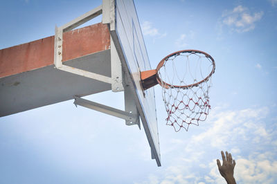 Cropped hand below basketball backboard