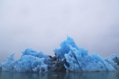 Ice floating on sea against sky