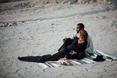 Rear view of couple sitting on street