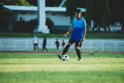 Full length of man playing soccer ball on field