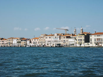 Canal against buildings in city on sunny day