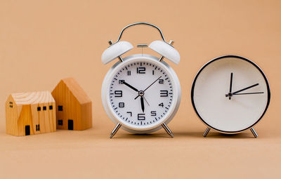 Close-up of alarm clock against pink background