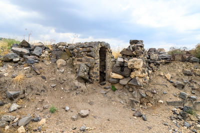 Stack of rocks on field against sky